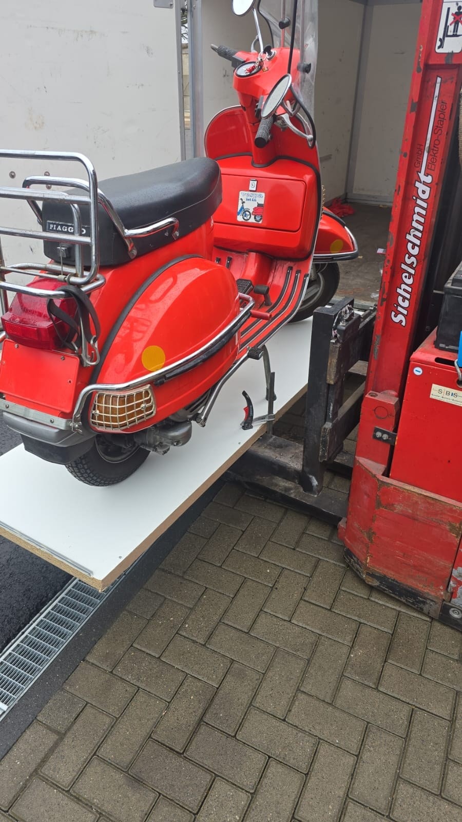 Rote Vespa auf einer improvisierten Arbeitsplattform
